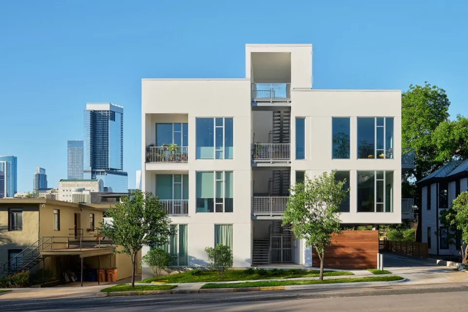 Rendering of white three-story single-stair building in Austin, Texas with staircase in the middle.